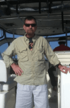 Here's an alt tag for the image: Man in sunglasses on a boat.