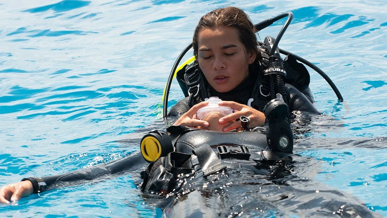 Scuba divers in the water, one unconscious.