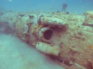 Sunken submarine covered in marine growth underwater.
