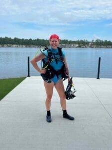 Scuba diver posing by a lake.
