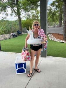 Woman with unicorn float and beach gear.
