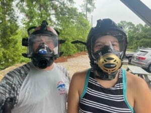 Two people wearing full-face diving masks.