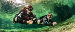 Two scuba divers holding hands underwater